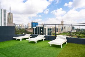 a group of white benches on the roof of a building at Paul Apartments in Nairobi