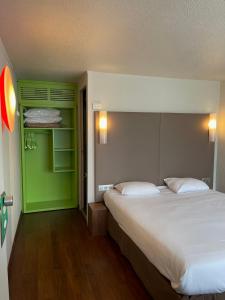 a bedroom with a large bed and a green wall at Campanile Montluçon ~ Saint-Victor in Saint-Victor