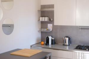 una cucina con armadi bianchi e un bancone all'arancia di Appartamento 25 min da Venezia a Quarto dʼAltino