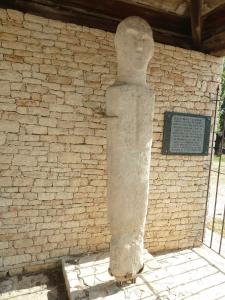 a statue of a person in front of a brick wall at U FARNIENTE in Patrimonio