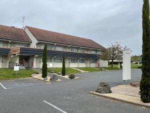 ein Gebäude mit einem Parkplatz davor in der Unterkunft Campanile Montluçon ~ Saint-Victor in Saint-Victor