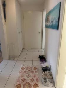 un corridoio con tappeto e scarpe sul pavimento di 01 quarto de casal Os demais cômodos da casa serão de uso compartilhado a Lucerna