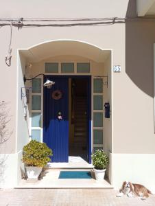 a dog laying in front of a house with a blue door at ''A casa di Lele'' in Avola