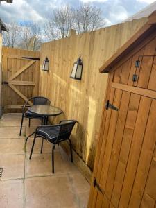 een houten hek met een tafel en stoelen op een patio bij Anchor Annex in Bristol