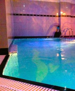 basen z błękitną wodą i zjeżdżalnią w obiekcie Hotel Arca lui Noe w mieście Sinaia