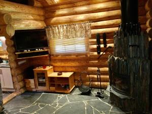 a log cabin room with a television and a table at Russet & Rowanberry - Rowanberry Holiday House in Kriilevälja