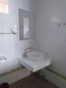 uma casa de banho branca com um lavatório e um espelho em Smile Home em Praia de Patong