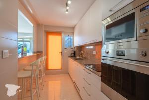 eine Küche mit weißen Schränken und einer gelben Tür in der Unterkunft CostaBlancaDreams Apartment Gran Sol in Calpe in Calpe