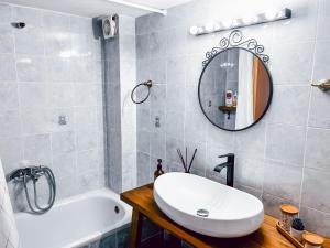 y baño con lavabo, bañera y espejo. en Iria Apartment en Polýgyros