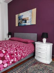 una camera viola con letto e comodino bianco di ''A casa di Lele'' ad Avola