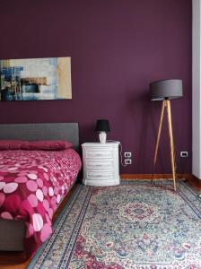 una camera da letto con pareti viola, un letto e una lampada di ''A casa di Lele'' ad Avola