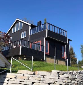 a large black house on top of some rocks at Leilighet nær Trondheim by. in Trondheim