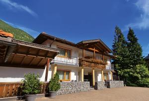 Cette grande maison dispose d'un balcon sur une montagne. dans l'établissement Ferienanlage Hechenbergerhof, à Bichlbach