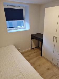 a bedroom with a bed and a window and a desk at Leilighet nær Trondheim by. in Trondheim