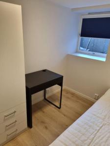 a bedroom with a small table next to a bed at Leilighet nær Trondheim by. in Trondheim