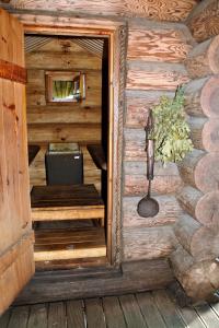 an entrance to a wooden cabin with a table at Russet & Rowanberry - Rowanberry Holiday House in Kriilevälja