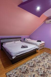 a bedroom with two beds and a purple ceiling at Vila Mario in Galaţi