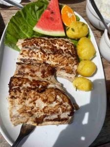 a plate of food with fish and fruit on a table at Sol-v-mar in Penha
