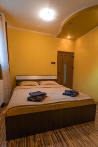 a bedroom with a large bed with two towels on it at Vila Mario in Galaţi