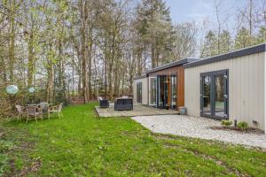 a small house with a patio and a yard at Chalet 41 met twee badkamers in Oosterwolde