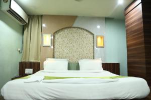 sypialnia z 2 łóżkami z białą pościelą w obiekcie Hotel Bhubaneswari Classic w mieście Brahmapur