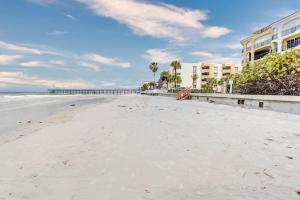 an empty beach with a pier in the background at Blue Beach Cottage in St. Pete Beach