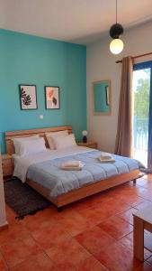 um quarto com uma cama grande e uma parede azul em Στούντιο με θέα τη θάλασσα em Itea