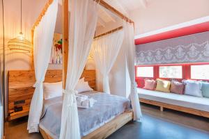 a bedroom with a bed with curtains and a window at Dmira Alacati in Alaçatı