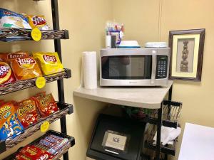 a microwave on a shelf next to some snacks at Monroe Street Suites in Pittsfield