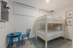 een kleine kamer met een stapelbed en een tafel bij Family Condo At Downtown in Oranjestad