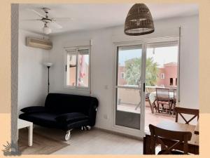a living room with a black chair and a window at Harea Coastal Penthouse Naturist Area in Playas de Vera