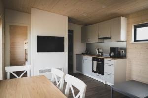 a kitchen with white cabinets and a table and chairs at Skógsnes II in Selfoss