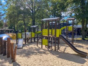 a playground with a slide in a park at Wood Cabin 2 personen in Baarle-Nassau