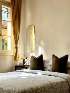 a bedroom with a bed and a mirror and a window at Stilnovo House in Florence