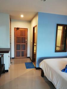 een slaapkamer met een bed en een blauwe muur bij Smile Home in Patong Beach