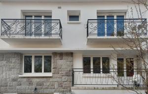 a white building with black balconies and windows at 3 Bedroom Stunning Home In Lanvaudan in Lanvaudan