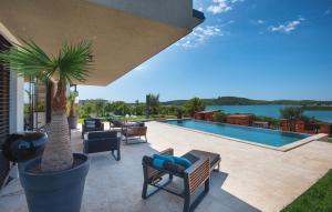 eine Terrasse mit einer Palme und einem Pool in der Unterkunft Awesome Home In Medulin With House Sea View in Medulin