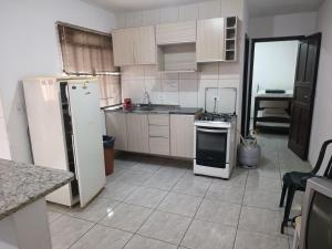 uma cozinha com um frigorífico e um fogão em ASSEL LOFT XAXIM em Curitiba