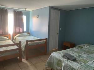 1 dormitorio con 2 camas individuales y ventana en HOSTAL QUILPUE, en Quilpué