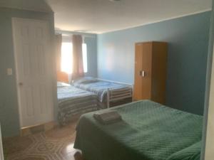 2 camas en una habitación con paredes azules en HOSTAL QUILPUE, en Quilpué
