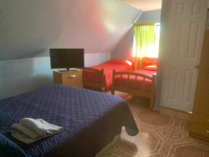 - une chambre avec un lit et un bureau avec une télévision dans l'établissement HOSTAL QUILPUE, à Quilpué