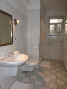 a white bathroom with a sink and a toilet at Hotel Villa Tosca in Hannover