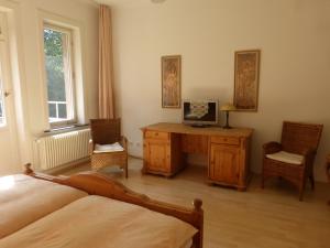 a bedroom with a bed and a desk with a television at Hotel Villa Tosca in Hannover