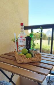 una cesta de comida y una botella de alcohol en una mesa en Апартамент в Oasis beach Kamchia - Стъпки в пясъка, en Kamchia