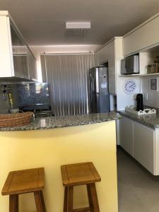 a kitchen with a counter and two wooden stools at Villa das águas in Estância