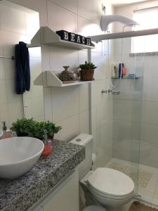 a bathroom with a toilet and a sink and a shower at Villa das águas in Estância