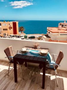 a black table and chairs with a view of the ocean at Acogedor y vistas al mar in Maspalomas