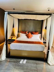 ein Schlafzimmer mit einem großen Bett mit Baldachin in der Unterkunft Boun's Hotel in Jaunde + 33 Fotos