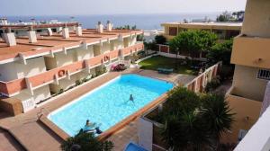 uma vista superior de uma piscina num edifício em Acogedor y vistas al mar em Maspalomas