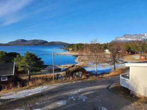 a view of a lake with a house and a road at Ulvsvåg Gjestgiveri og Fjordcamping AS in Ulvsvåg
